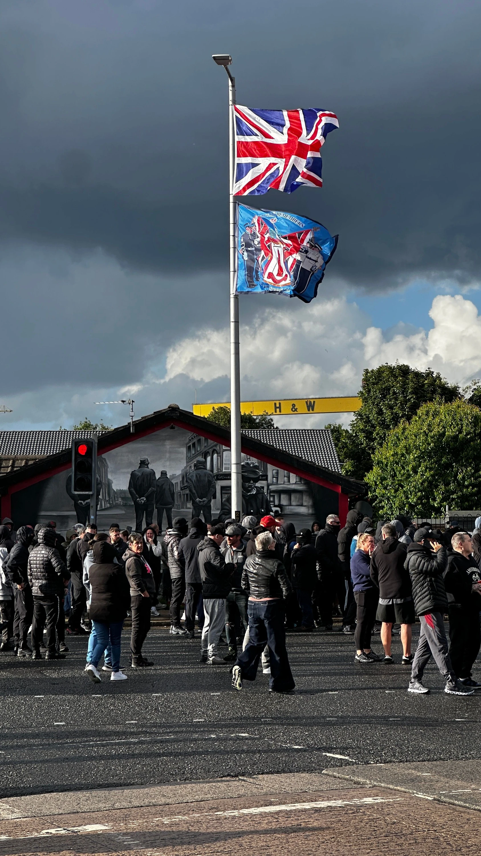 Demonstranten blockieren eine Straße im Osten Belfasts, an der Fahnenstange wehen der Union-Jack und eine Flagge zur Erinnerung an die Gründungszeit Nordirlands