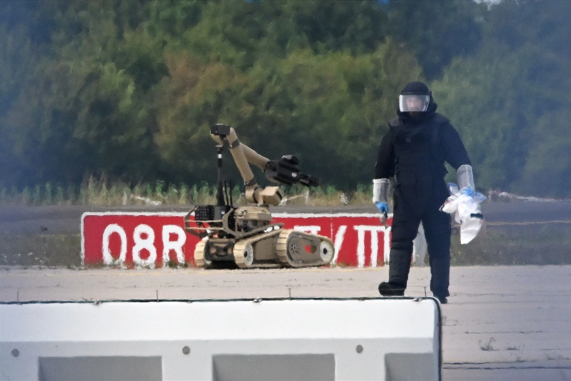 Ein Kriminaltechniker ist neben einem Sprengroboter in der Nähe eines ukrainischen Flugzeugs auf dem Flughafen Leipzig/Halle im Einsatz.
