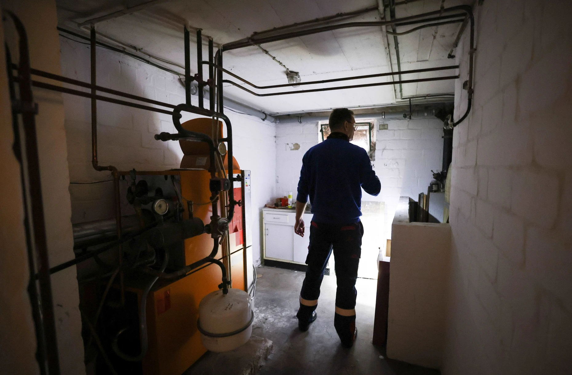 ARCHIV - 09.11.2021, Schleswig-Holstein, Itzehoe: Ein Mitarbeiter eines Diesel- und Heizöl-Unternehmens prüft die Kunststofftanks in einem Heizungskeller bei der Heizöllieferung für ein Einfamilienhaus. (Zu dpa "Ampel-Politiker wollen Entlastungen auch für Nicht-Gaskunden"= Foto: Christian Charisius/dpa +++ dpa-Bildfunk +++