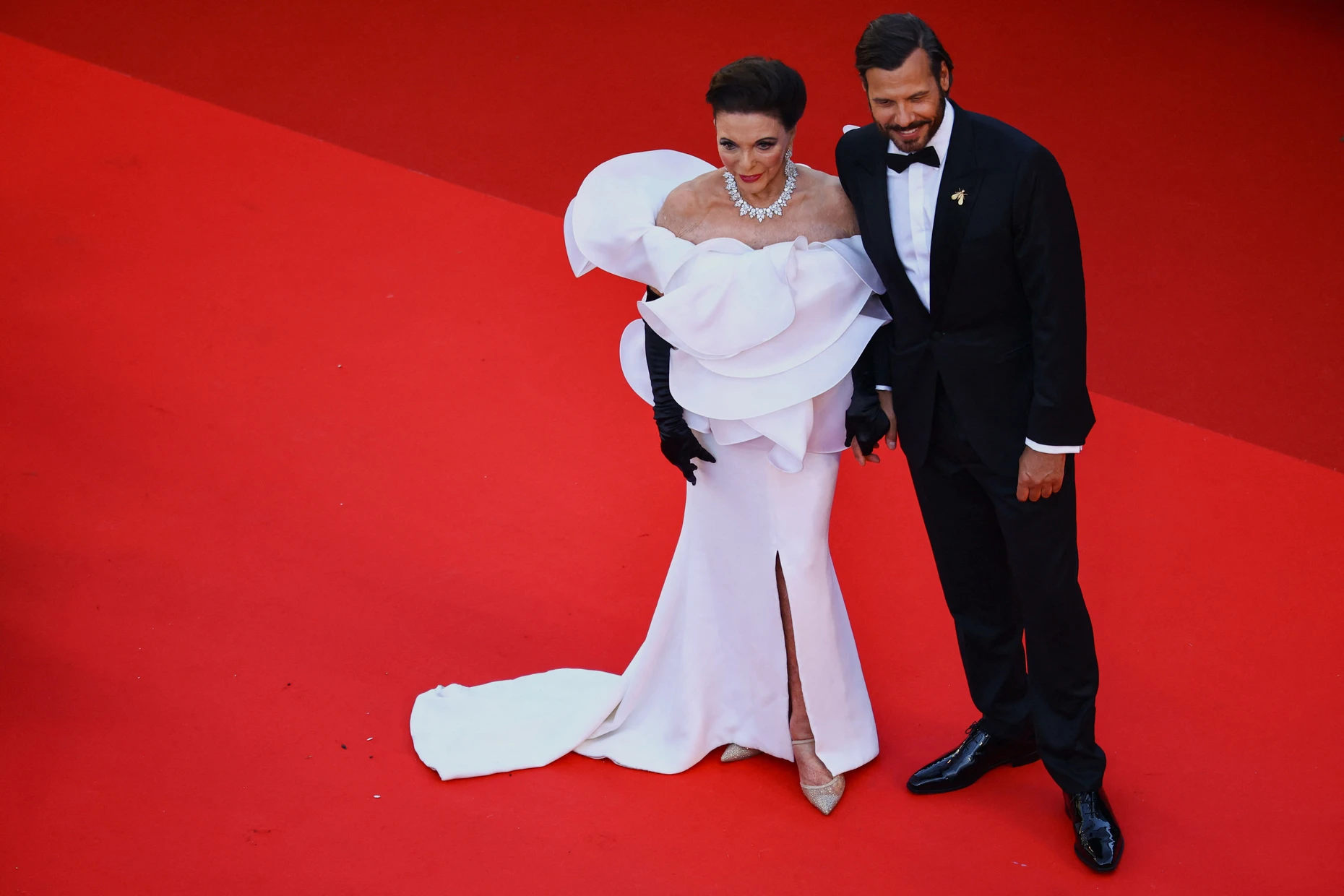 Große Robe in CanneS: Joan Collins mit Laurent Lafitte im Mai 2026 auf dem roten Teppich