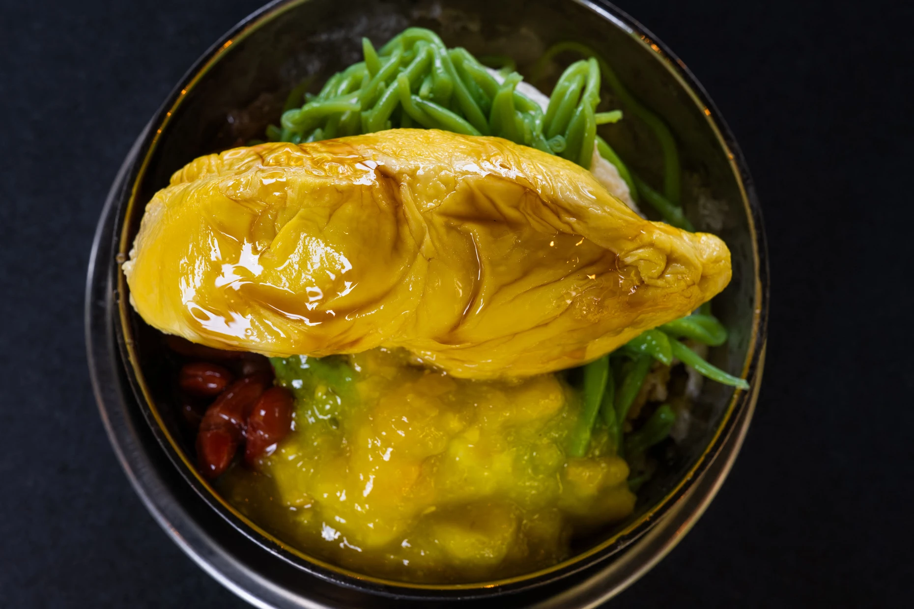 Das Cendol-Dessert wird mit Durianfruchtfleisch garniert.