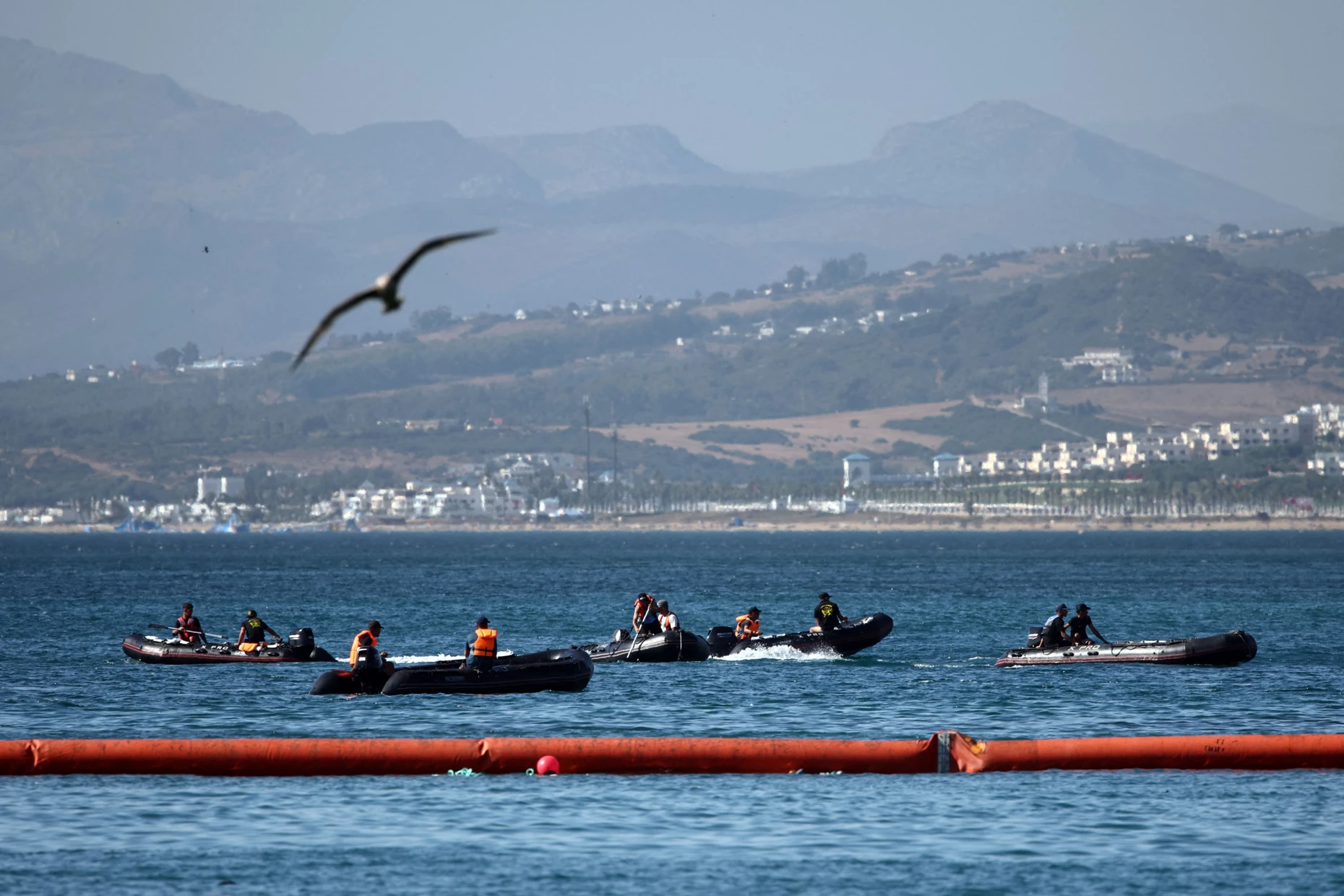 Migranten an Bord von Schlauchbooten bewegen sich am Sonntag in Richtung der schwimmenden Barriere, die Spanien in Ceuta errichtet hat.