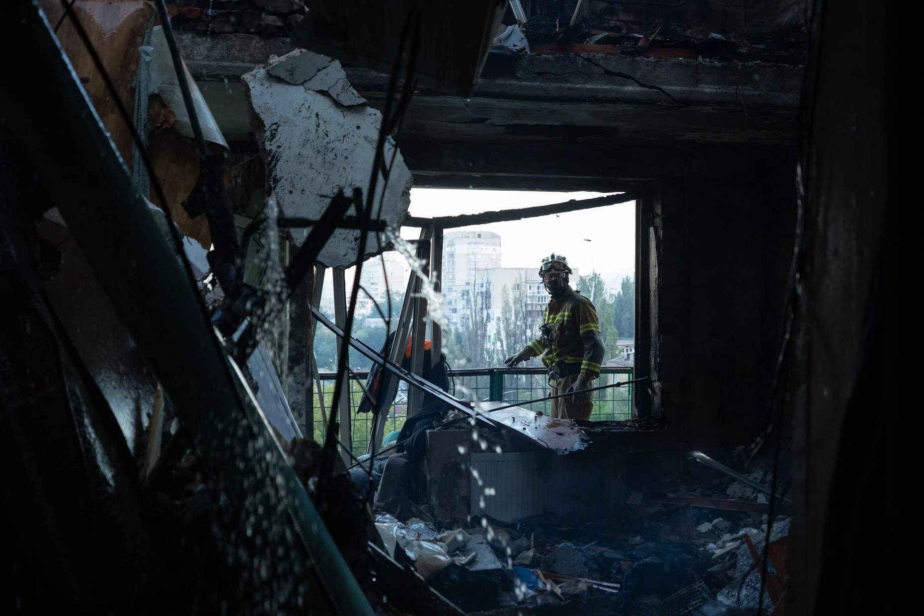 Ein Feuerwehrmann untersucht ein zerstörtes Wohnhaus.