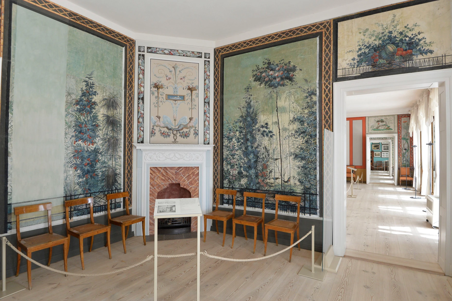 Mit Pflanzenbildern bedruckte Tapeten und schlichtes Mobiliar: der Gartensaal in Schloss Paretz