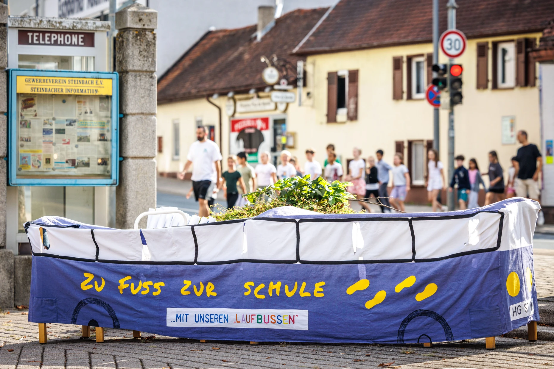 Mit Schlitzen: Um für die Aktion gegen Elterntaxis zu werben, schlupfen die Kinder hin und wieder in den Laufbus aus Stoff.