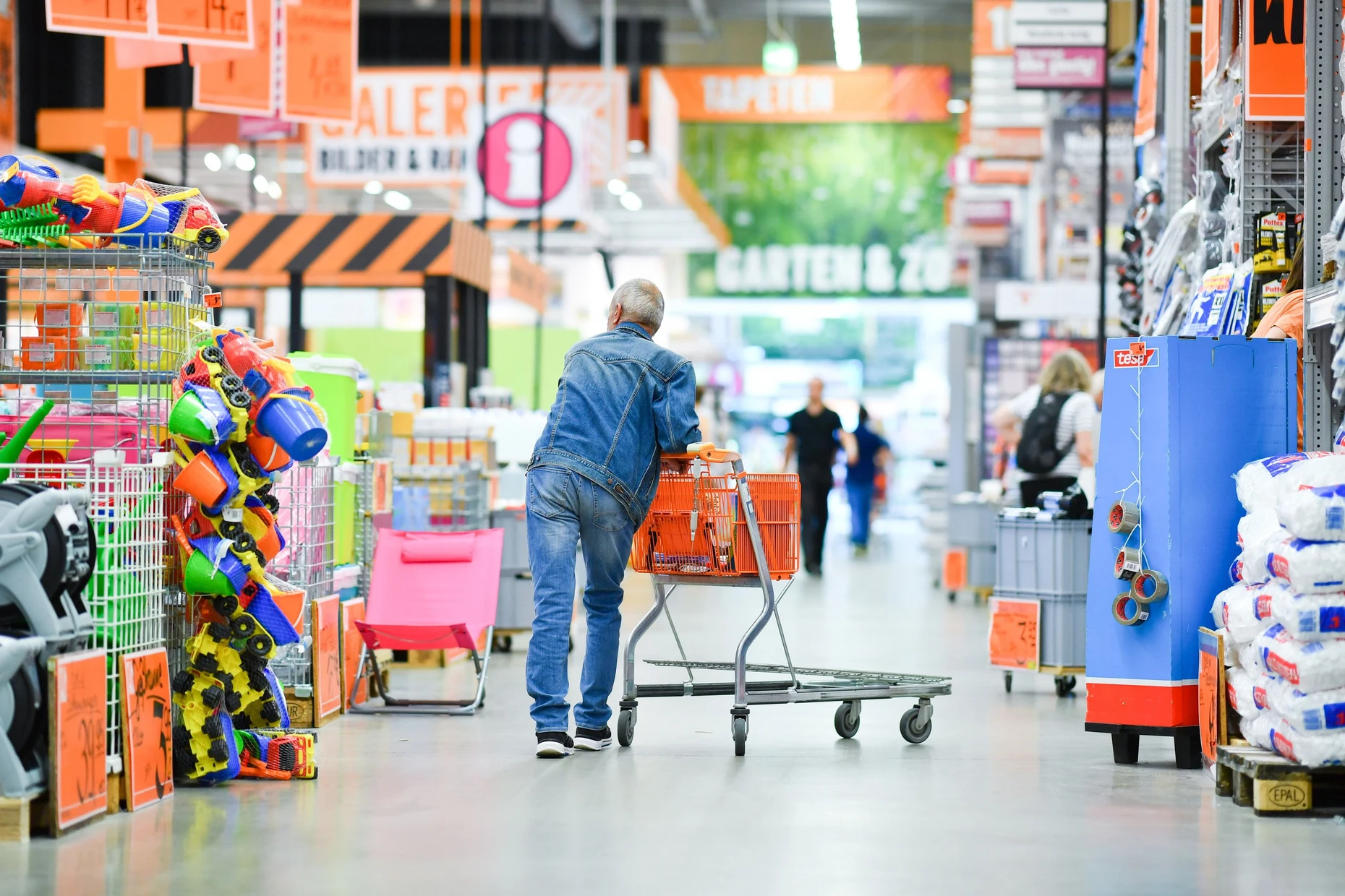 Ein Kunde schiebt in einem Baumarkt der Firma Hornbach seinen Einkaufswagen an den Verkaufsregalen vorbei.