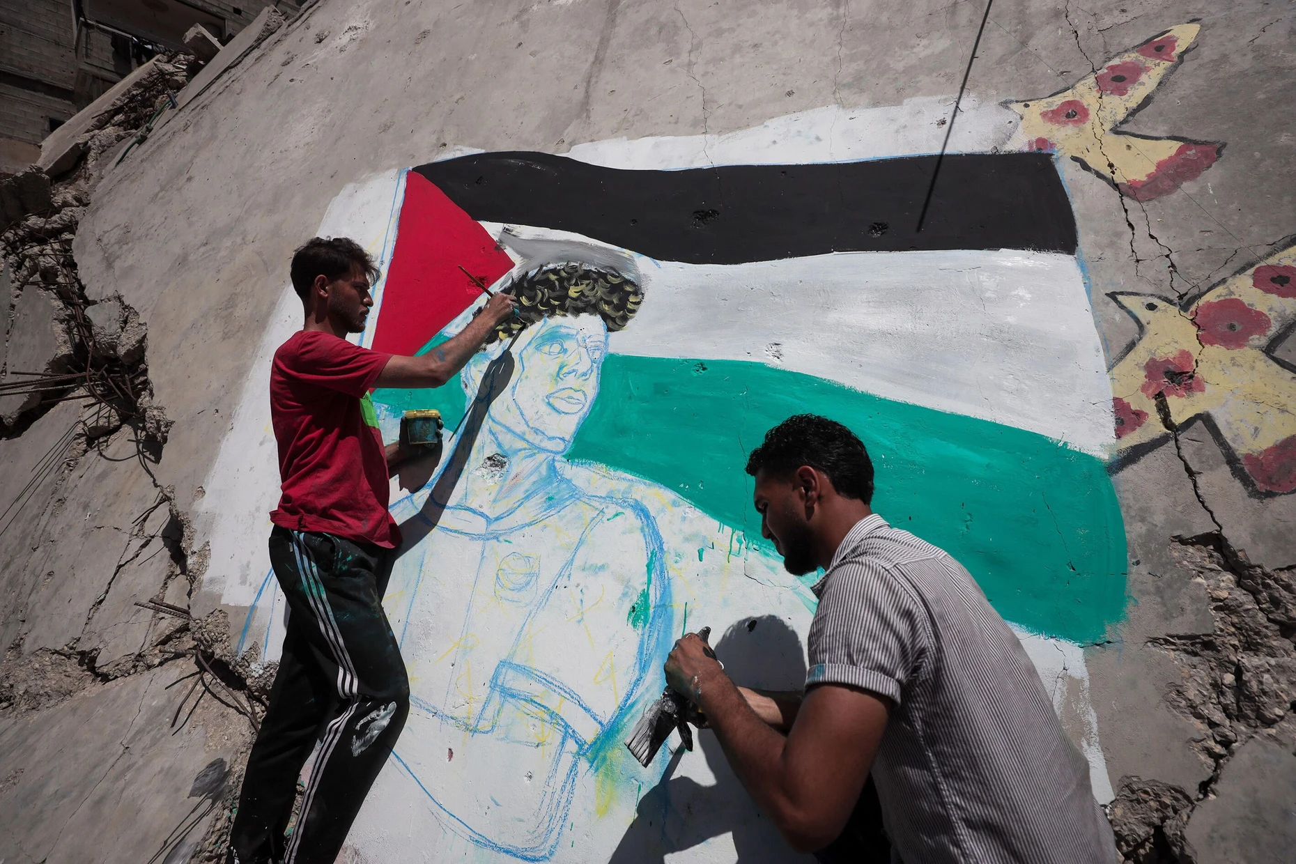 Heldenfigur: In den Ruinen von Gaza malen zwei Männer den spanischen Nationalspieler Yamal mit der Flagge Palästinas.