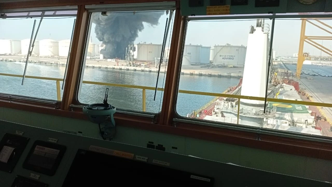 Foto von brennendem Öltank nach Angriff im Hafen von Dschabal Ali, fotografiert von dem Schiff Banglar Joyjatra