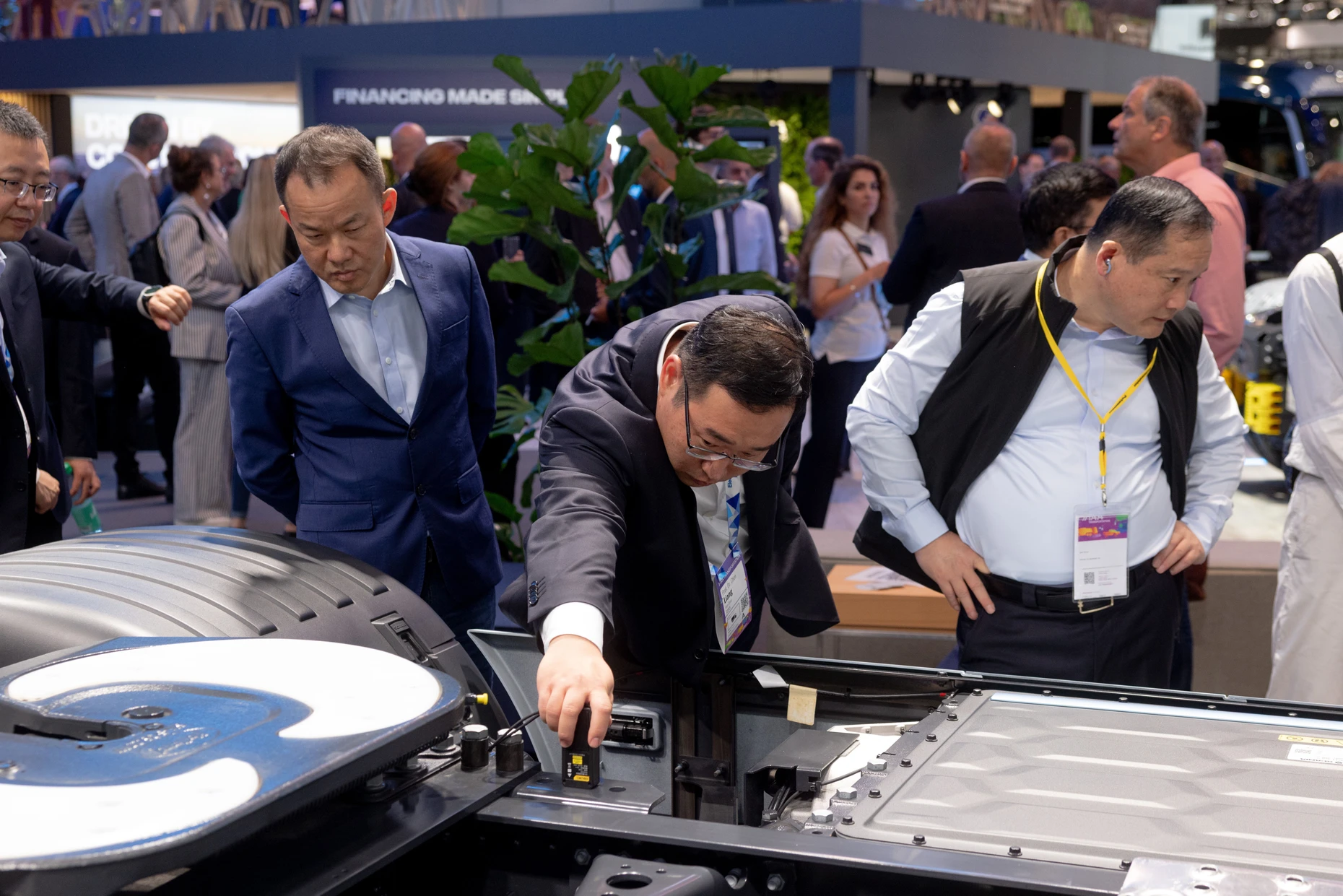 An IAA visitor measures something on a new Scania electric truck.