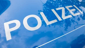 Frau beißt Polizistin in die Wange