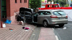 Auto fährt in Gruppe von Feiernden