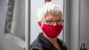 Eine Reisende am Flughafen über die Corona-Warn-App