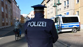 Neun Polizisten aus Cottbus posieren vor rechtsextremem Graffito