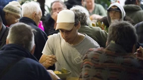 Obdachlose und Banker an einem Tisch