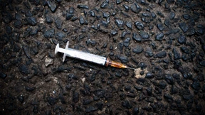 Drogenabhängiger verletzte Verkäufer mit Spritze