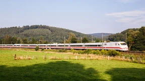 Mann läuft über Bahngleise und zeigt Lokführer den Stinkefinger