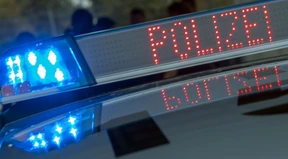 Zwei junge Männer zielen mit Maschinenpistolen-Attrappe auf Passanten