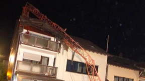 Kran stürzt auf Wohnhaus