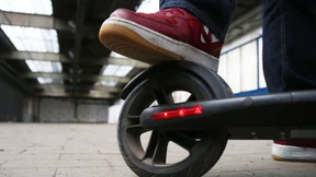 Mann fährt mit Elektro-Roller über Autobahn