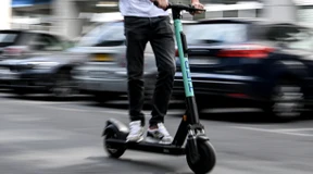 Junger Mann fährt mit E-Scooter auf Autobahn 2