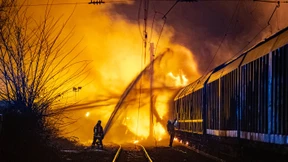 Güterwaggons mit Spraydosen in Flammen