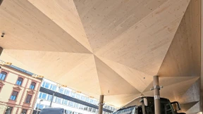 Fahrgäste warten unter Holzdach