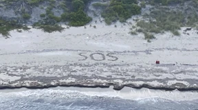 Gestrandeter malt „SOS“ in Sand und wird gerettet