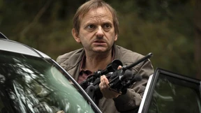 Ein Mann greift zum Gewehr