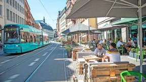 Tische, Stühle und Pflanzen statt Parkplätze