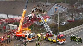 Kran stürzt auf Supermarkt - eine Tote