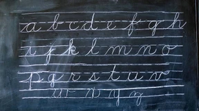 Mit Schiefertafel und Rohrstock