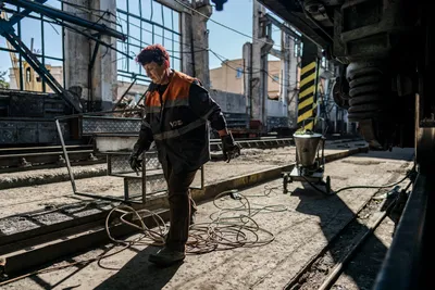 Echte Handarbeit: Für die Eisenbahn arbeiten 170.000 Menschen. Zwei von ihnen schweißen die beschädigte Lok mit dem grau-roten Tarnmuster.