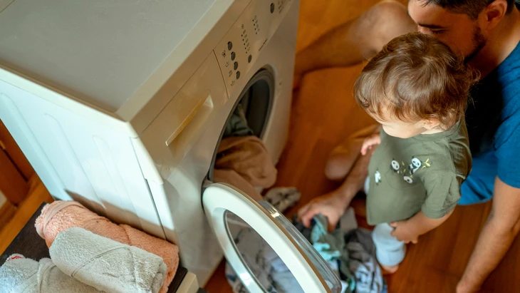 Dass der Vater die Waschmaschine füllt, wird aufmerksam begleitet.