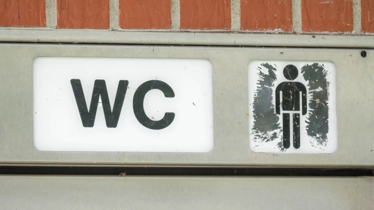 Der Schriftzug „WC“ hängt an einer öffentlichen Toilette. (Symbolbild)