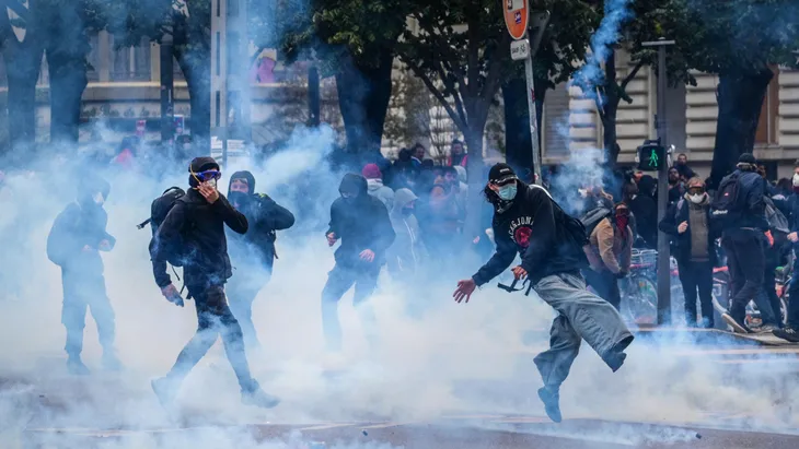Demonstranten treten Tränengasgranaten weg während einer Demonstration am 24. Oktober in Lyon.