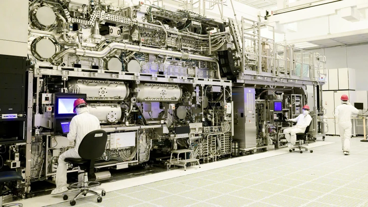 FILE PHOTO: Workers are seen in front of a "High NA EUV" lithography system at an Intel facility in Hillsboro, Oregon, U.S. in this handout image obtained by Reuters on April 19, 2024. Intel said on April 18 that it has become the first company to assemble one of the machines made by Dutch computer chip equipment supplier ASML, which are expected to lead to new generations of smaller, faster computer chips. Intel Corporation/Handout via REUTERS/File Photo