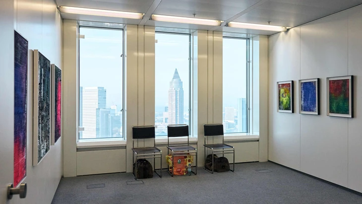 An den Wänden Kunst, vor den Fenstern der Messeturm, unter dem Stuhl eine Einkaufstasche: vor der Eröffnung im „House of Galleries“