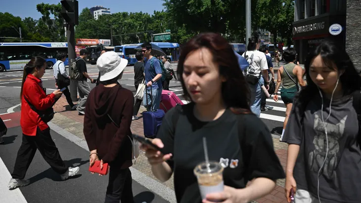Menschen überqueren einen Fußgängerüberweg in Seoul.