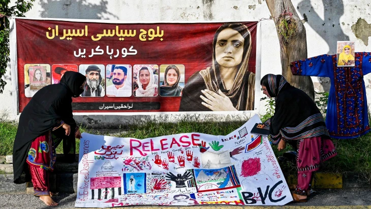Demonstranten stehen am Internationalen Tag der Opfer von Verschleppungen am 30. August 2025 in Islamabad neben einem Banner mit der inhaftierten Aktivistin Mahrang Baloch, für die sich Imaan Mazari eingesetzt hatte.