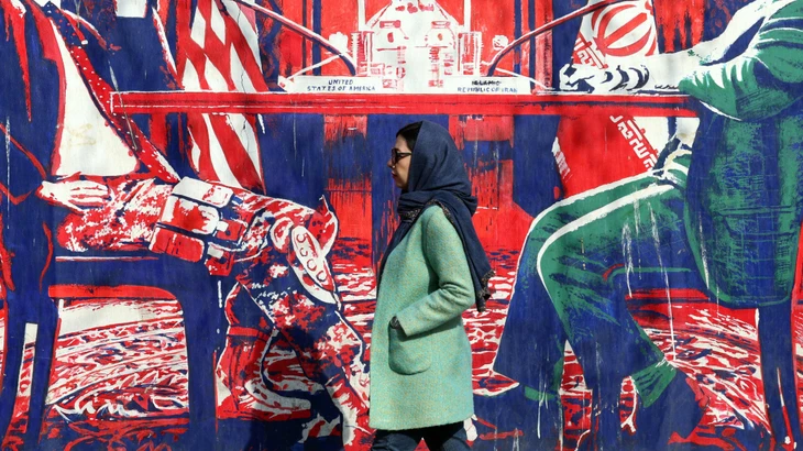 Ein Wandgemälde in Teheran zeigt einen amerikanischen Cowboy und einen schreibenden Iraner an einem Tisch.