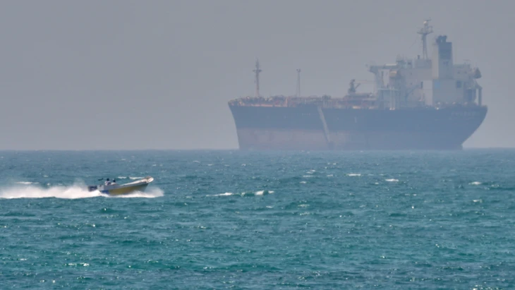 Ein Boot fährt vergangenen Samstag an einem Tanker vorbei, der in der Straße von Hormus vor Anker liegt.