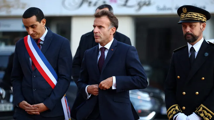 Frankreichs Präsident Emmanuel Macron am Freitagabend mit dem Bürgermeister von Trappes, Ali Rabeh, in der Nähe des Tatorts