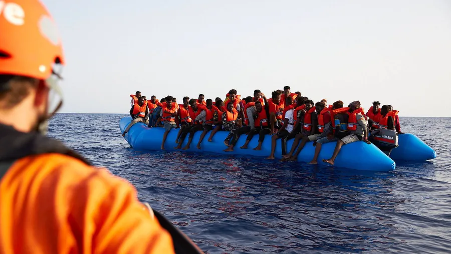 Die von der Seenotrettungsorganisation Sea-Eye herausgegebene Aufnahme zeigt einen Seenotretter der zu einem Flüchtlingsboot schaut.