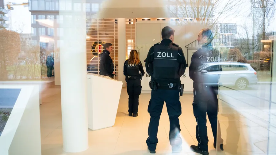 Zoll-Beamte stehen im Eingangsbereich des Unternehmenssitzes in Hamburg.