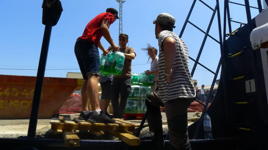 Die Crew verstaut Wasservorräte an Deck der „Alan Kurdi“.