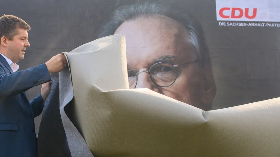 Sven Schulze, Vorsitzender der CDU Sachsen-Anhalt, enthüllt ein Wahlplakat der CDU, auf dem ein Porträt des Ministerpräsidenten Reiner Haseloff zu sehen ist.