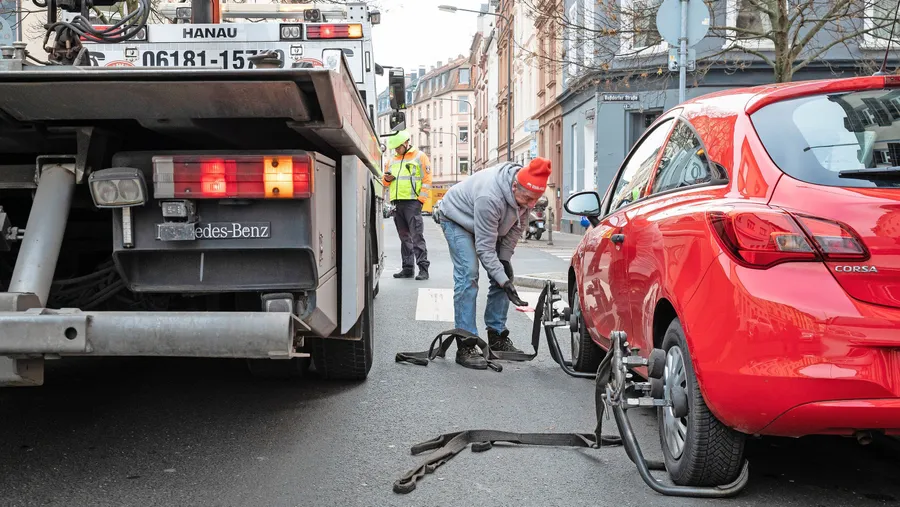 Zu nah am Zebrastreifen: Der Mann vom Abschleppdienst, den die Verkehrspolizei gerufen hat, macht einen Wagen zum Abtransport fertig.