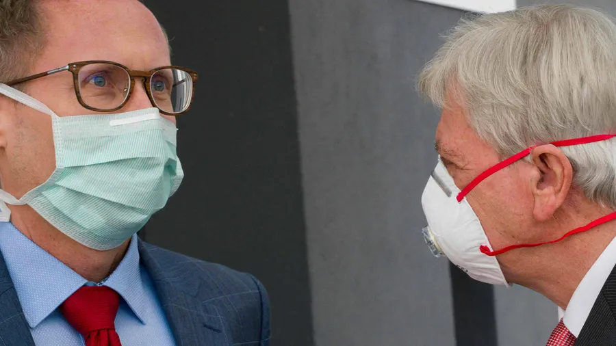 Ausgerüstet: Volker Bouffier (rechts) und Kai Klose unterhalten sich und tragen dabei Schutzmasken.