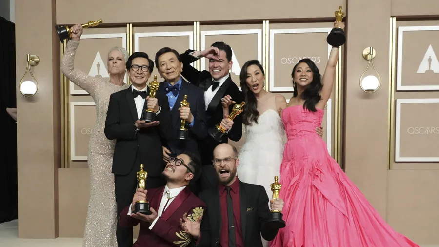 „Everything Everywhere All at Once“ gewann sieben Oscars: Jamie Lee Curtis (von links oben), Ke Huy Quan, James Hong, Jonathan Wang, Michelle Yeoh und Stephanie Hsu sowie davor die beiden Regisseure Daniel Kwan (links) und Daniel Scheinert