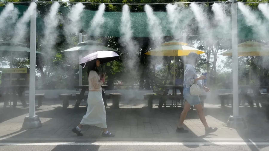 Südkorea macht es vor: Passanten gehen unter einer Nebelanlage zur Abkühlung vorbei.
